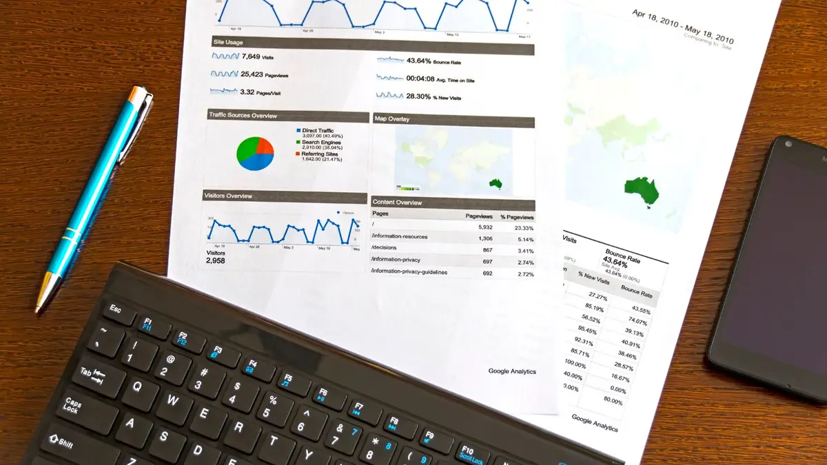 Rapport de statistiques imprimé posé sur un bureau, à côté d'un clavier et d'un stylo